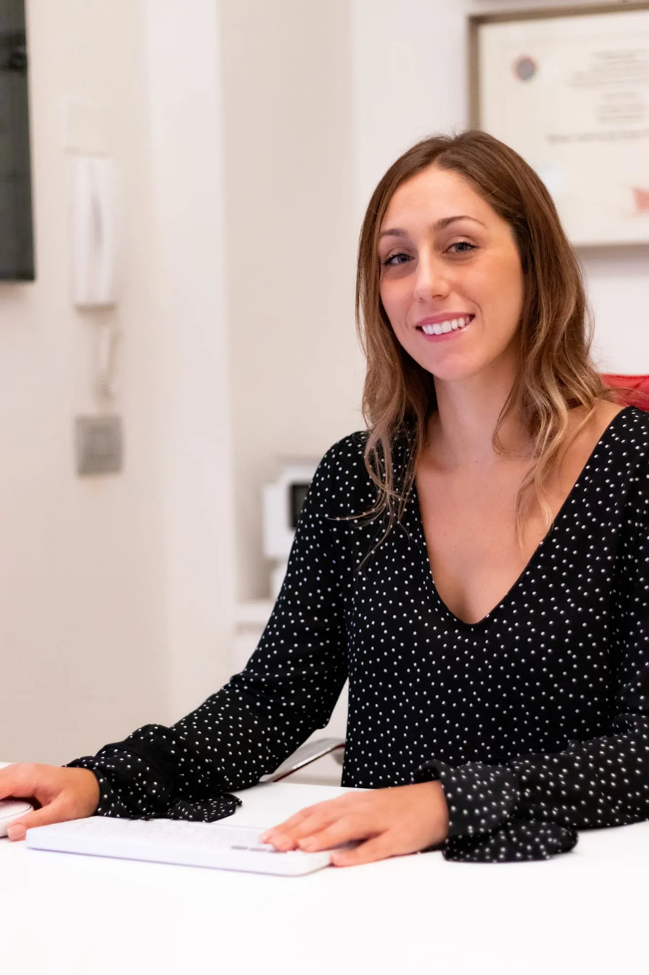 La dottoressa Carlotta Castelli sorridente alla scrivania dello studio